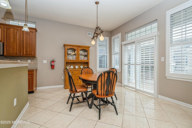 dining room featuring plenty of natural light, baseboards, and light tile patterned flooring