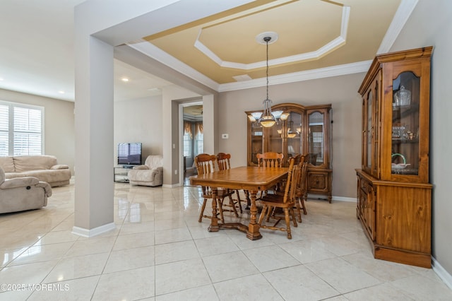 dining space with ornamental molding, a tray ceiling, light tile patterned flooring, and baseboards