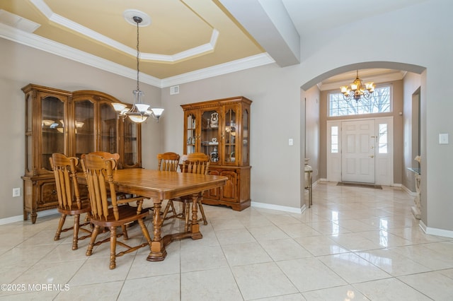 dining area featuring a chandelier, arched walkways, a raised ceiling, and light tile patterned floors