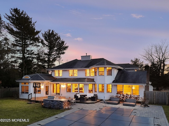 rear view of house featuring a patio, a chimney, outdoor lounge area, and fence