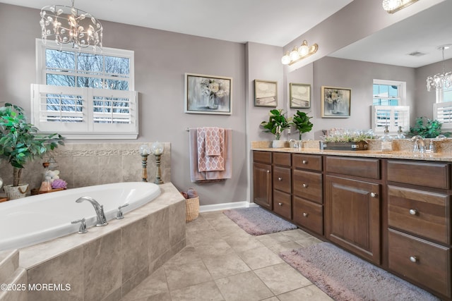 full bathroom with double vanity, a garden tub, tile patterned flooring, and a chandelier