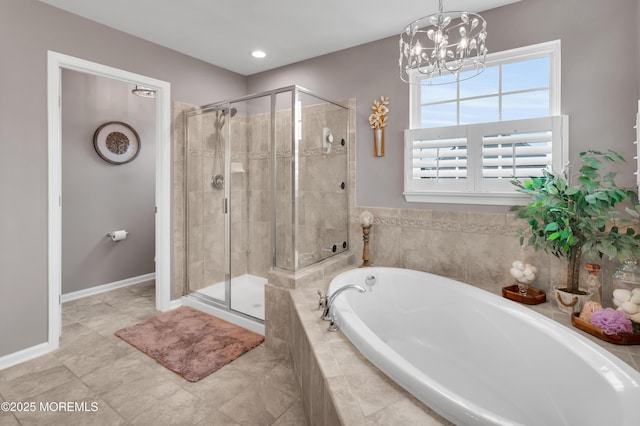 bathroom with a garden tub, a shower stall, baseboards, and an inviting chandelier