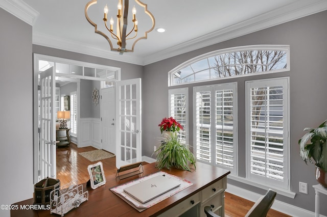 office featuring ornamental molding, wainscoting, a notable chandelier, and wood finished floors