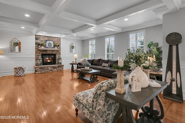 living area featuring a decorative wall, a fireplace, coffered ceiling, beam ceiling, and hardwood / wood-style floors