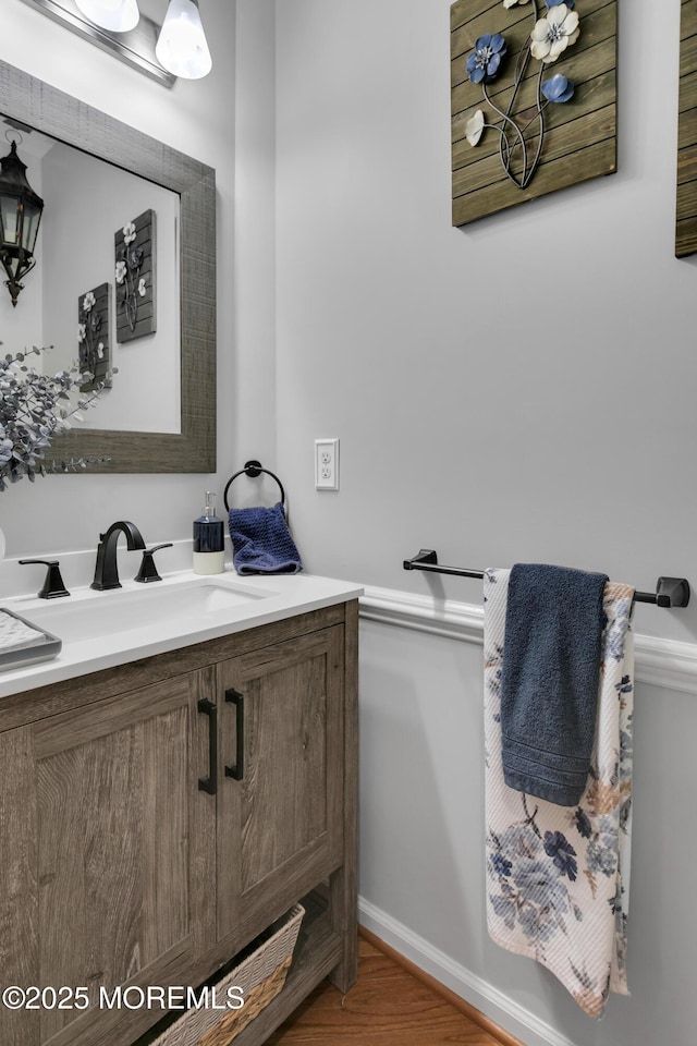 bathroom with wood finished floors, vanity, and baseboards