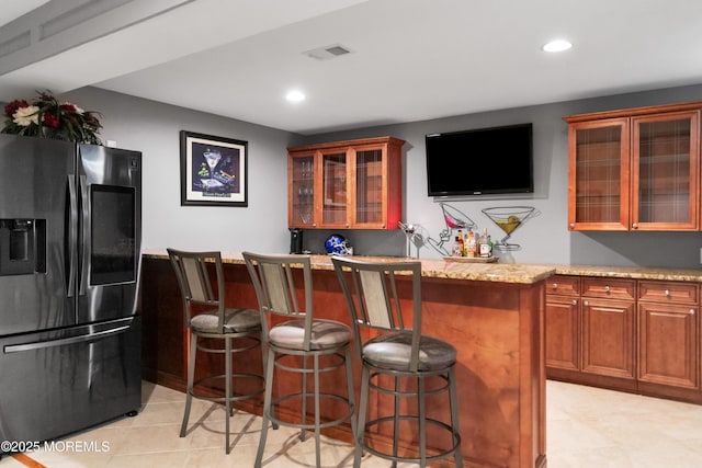 bar with a dry bar, stainless steel refrigerator with ice dispenser, visible vents, and recessed lighting