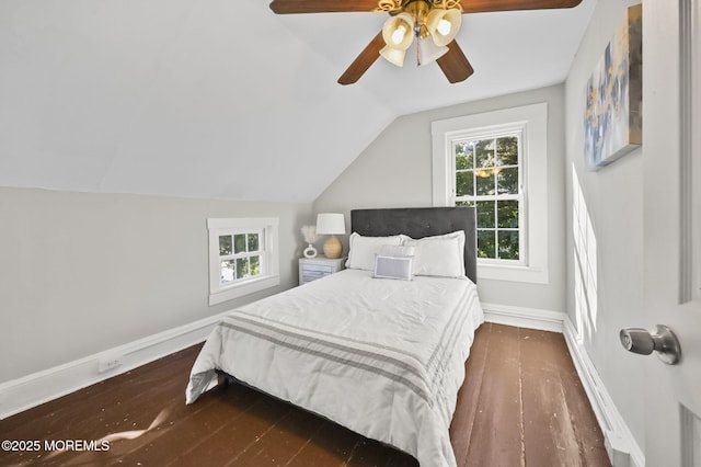 bedroom with dark wood finished floors, vaulted ceiling, baseboards, and ceiling fan