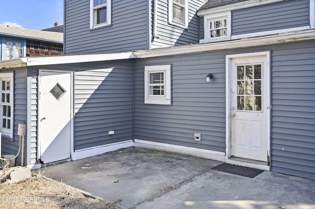 view of exterior entry with a patio