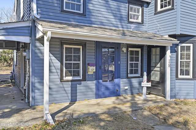 property entrance featuring roof with shingles