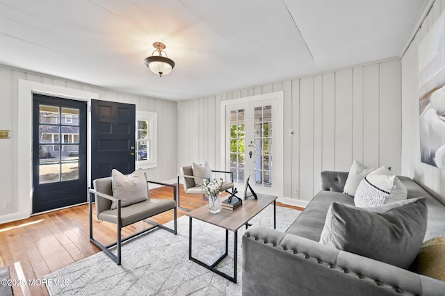 living room featuring light wood finished floors, french doors, and baseboards