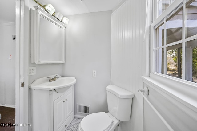 bathroom with visible vents, vanity, toilet, and tile patterned floors