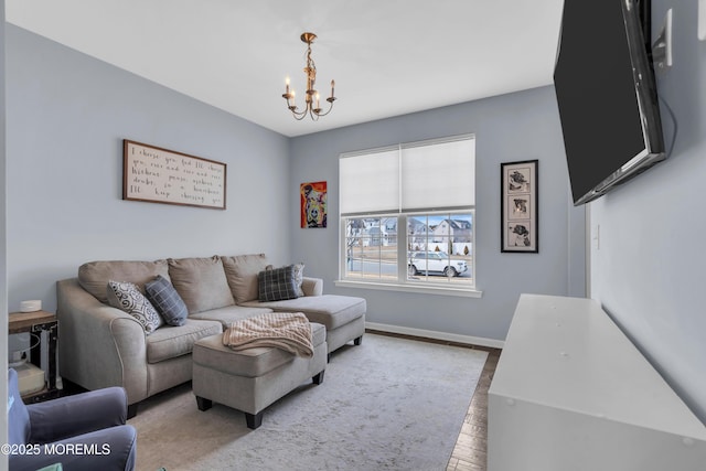 living area with an inviting chandelier, baseboards, and wood finished floors