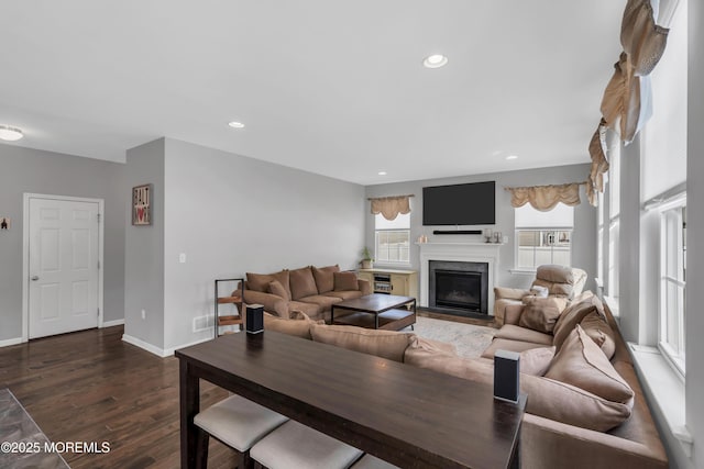 living area with dark wood-type flooring, a high end fireplace, baseboards, and recessed lighting