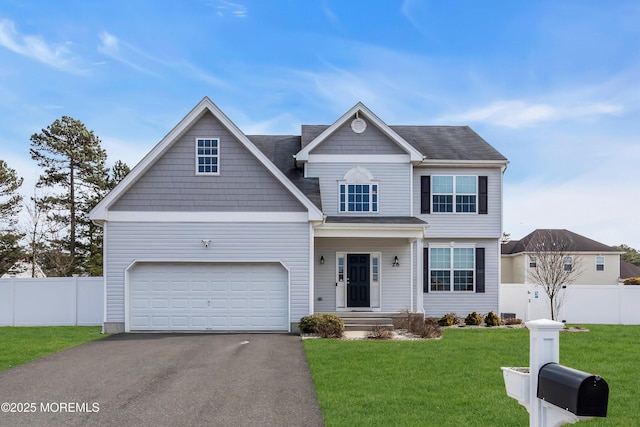 view of front of home featuring fence, aphalt driveway, and a front yard