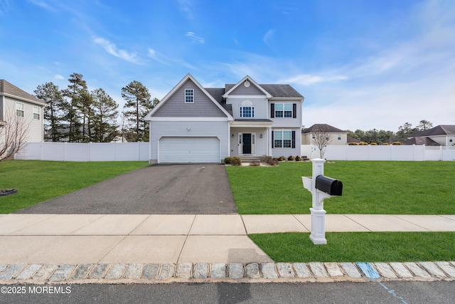 view of front facade featuring aphalt driveway, fence, and a front lawn