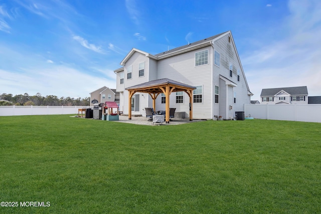 rear view of house with a yard, a gazebo, a patio area, cooling unit, and a fenced backyard