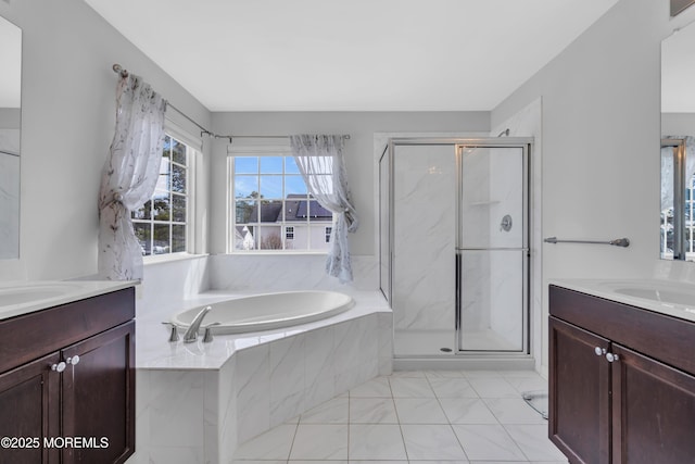 full bathroom featuring a stall shower, two vanities, and a bath