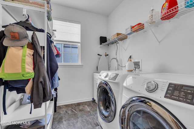 washroom with baseboards, cabinet space, and washer and dryer