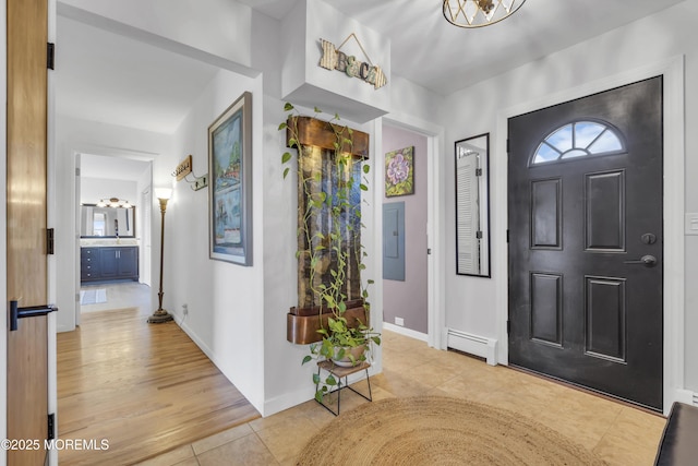 entrance foyer with electric panel, light tile patterned flooring, baseboards, and baseboard heating