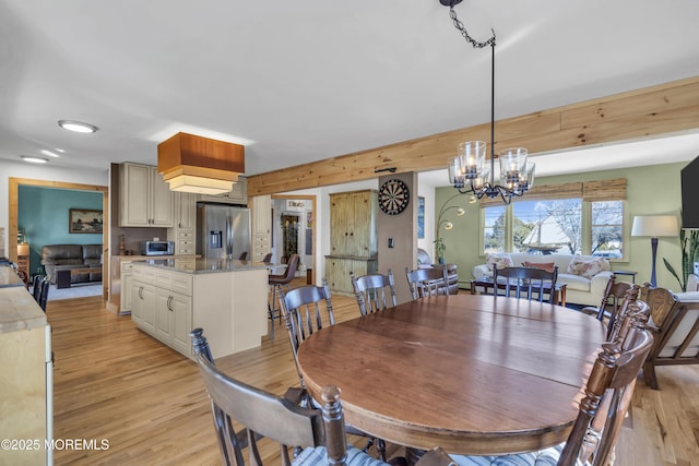 dining room with a notable chandelier and light wood-style floors