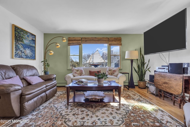 living room with baseboard heating and wood finished floors