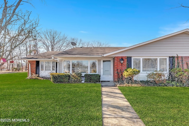 view of front of home featuring brick siding and a front yard