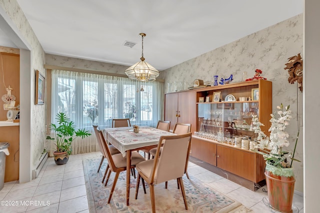 dining space with light tile patterned floors, a chandelier, visible vents, and wallpapered walls