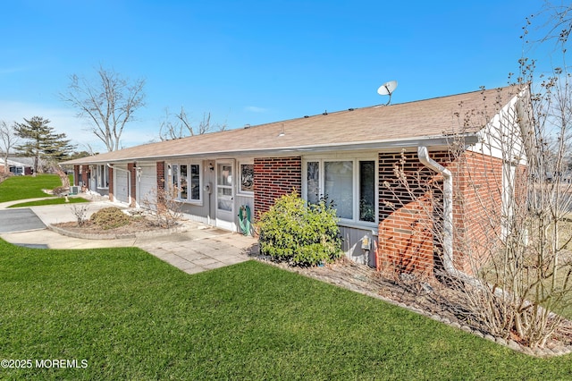 view of front facade featuring an attached garage, a front lawn, concrete driveway, and brick siding