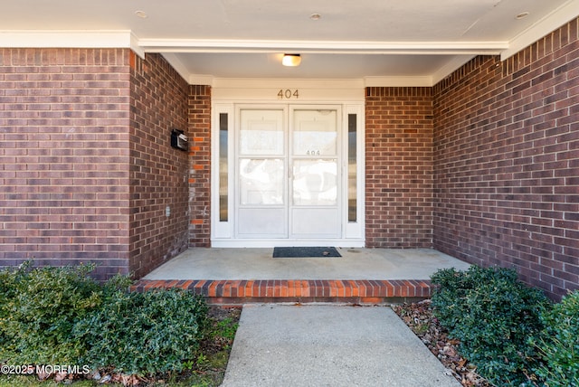 entrance to property featuring brick siding