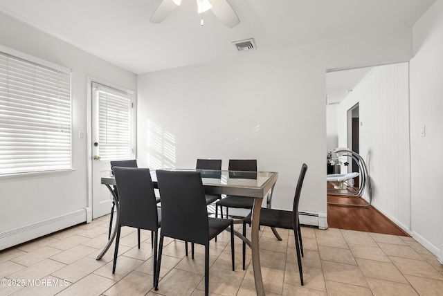 dining space featuring visible vents, a baseboard heating unit, a ceiling fan, light tile patterned flooring, and baseboards