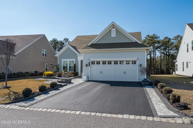 view of front of house with a garage, a front yard, aphalt driveway, and roof with shingles