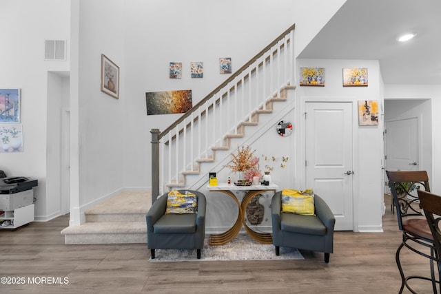 stairway featuring recessed lighting, visible vents, baseboards, and wood finished floors