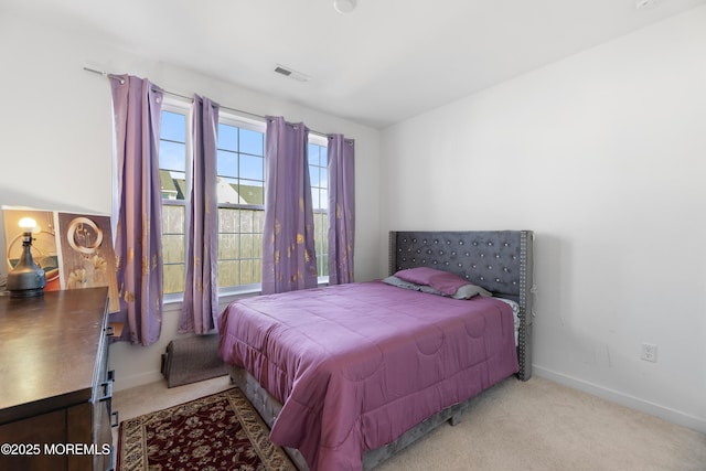 carpeted bedroom with visible vents and baseboards