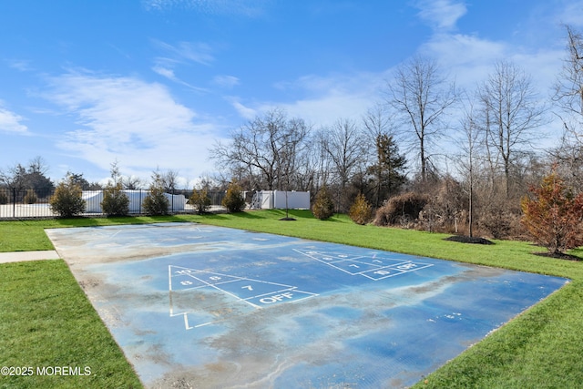 view of property's community with shuffleboard, a lawn, and fence