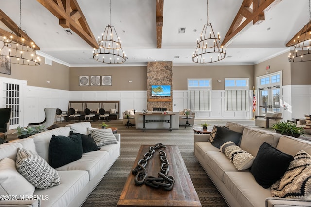 sunken living room with beam ceiling, a wainscoted wall, a fireplace, a decorative wall, and a high ceiling