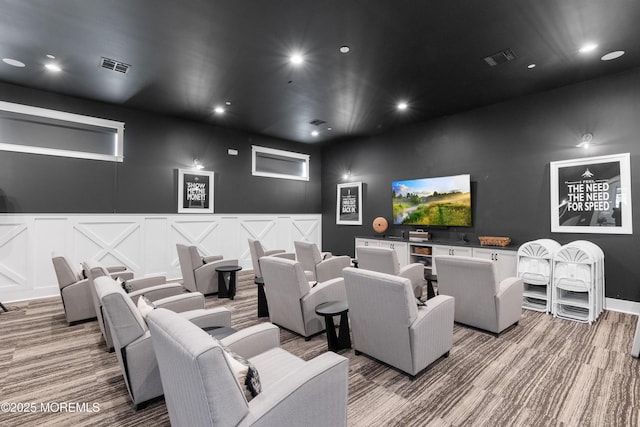 home theater room featuring visible vents, a decorative wall, and recessed lighting