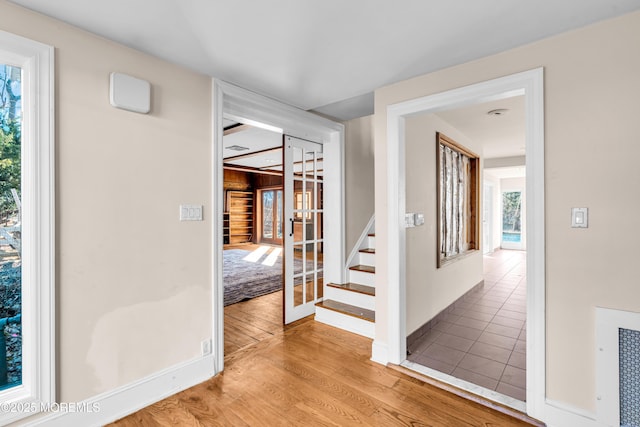 hall featuring french doors, stairway, wood finished floors, and baseboards