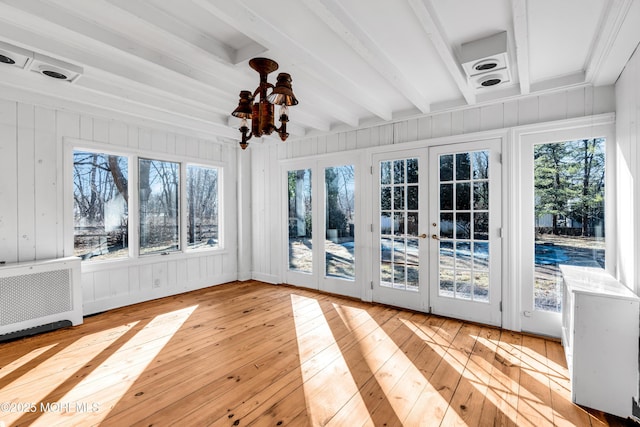 unfurnished sunroom featuring beam ceiling and french doors