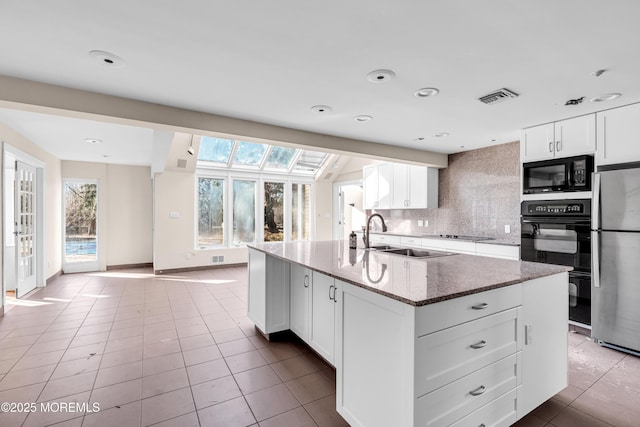 kitchen with stone counters, visible vents, backsplash, white cabinetry, and black appliances