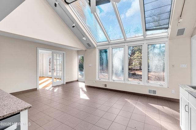 unfurnished living room featuring a wealth of natural light, a skylight, and visible vents