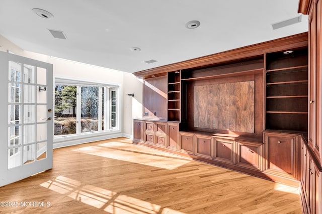 unfurnished living room featuring visible vents and light wood-style flooring