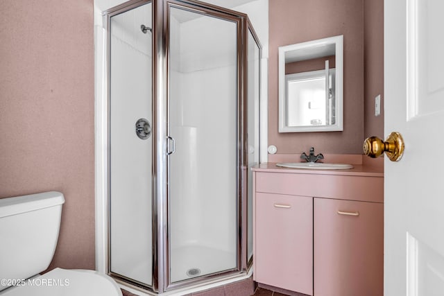 full bath featuring a stall shower, vanity, and toilet