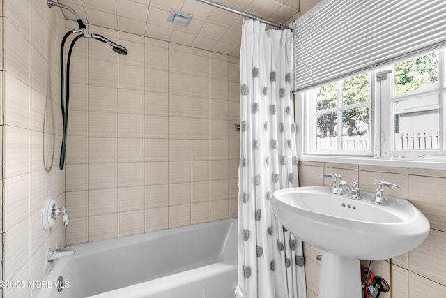 full bathroom featuring a sink and shower / bathtub combination with curtain