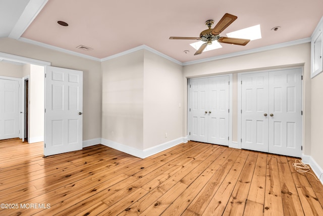 unfurnished bedroom with light wood-style floors, crown molding, and baseboards