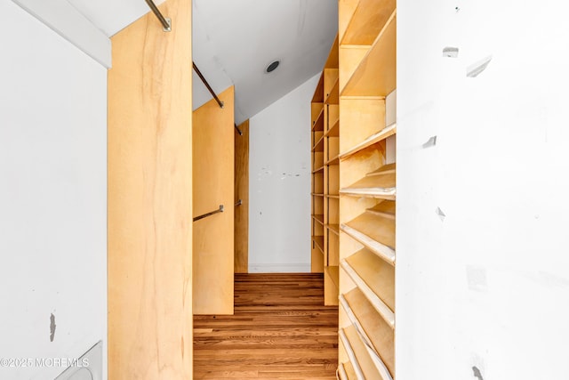 walk in closet with wood finished floors