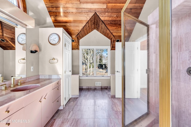 full bath featuring lofted ceiling, wood ceiling, vanity, a shower stall, and baseboards