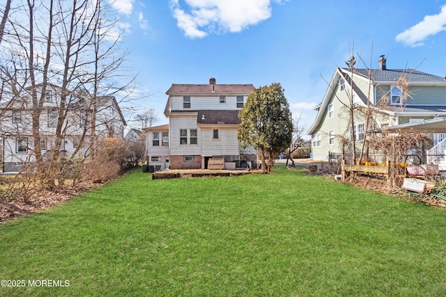 back of property with a chimney and a yard