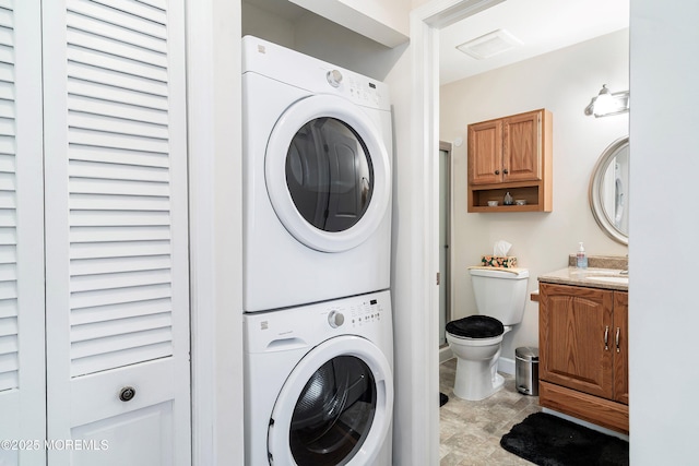 laundry room featuring laundry area, visible vents, and stacked washer / drying machine