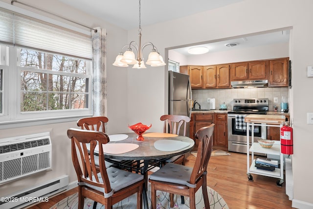 dining space featuring a wall unit AC, light wood-style floors, a baseboard radiator, and visible vents