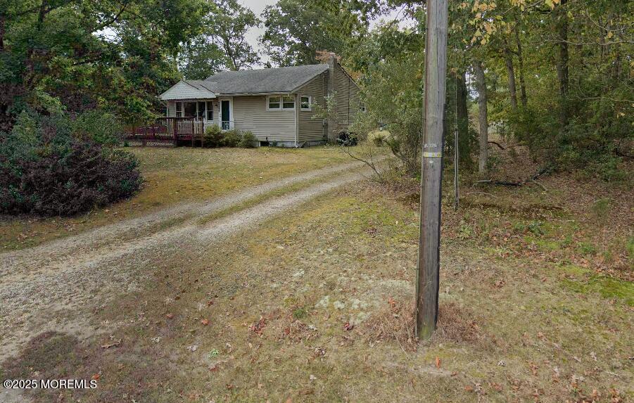 view of front of home featuring driveway and a wooden deck